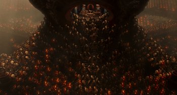 Movie still from “Hellboy II: The Golden Army” (2008), directed by Guillermo del Toro – A large group of people sitting in a room; Extreme Wide shot, High angle
