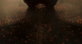 Movie still from “Hellboy II: The Golden Army” (2008), directed by Guillermo del Toro – A large group of people gathered in a dark room; Extreme Wide shot, Overhead angle
