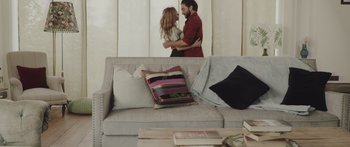 Movie still from “Help” (2021), directed by Blake Ridder – A man and a woman hugging on a couch; Wide shot, Over the shoulder angle