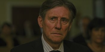 Movie still from “Hereditary” (2018), directed by Ari Aster – An older man wearing a suit and tie; Close Up shot, Over the shoulder angle