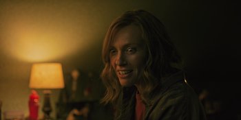 Movie still from “Hereditary” (2018), directed by Ari Aster – A person smiling for the camera; Close Up shot, Low angle