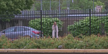 Movie still from “Hereditary” (2018), directed by Ari Aster – A woman standing in front of a metal fence; Extreme Wide shot, Over the shoulder angle