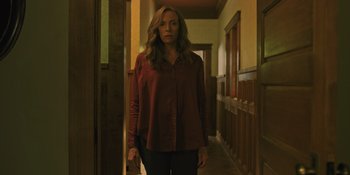 Movie still from “Hereditary” (2018), directed by Ari Aster – A woman standing in the hallway of a building; Medium shot, Low angle