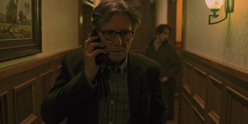 Movie still from “Hereditary” (2018), directed by Ari Aster – A man with glasses is talking on a cell phone; Medium shot, Low angle