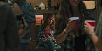 Movie still from “Hereditary” (2018), directed by Ari Aster – A woman sitting on the floor with a drink in her hand; Medium shot, Over the shoulder angle