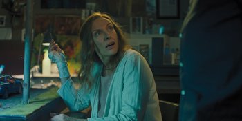 Movie still from “Hereditary” (2018), directed by Ari Aster – A woman sitting at a table looking up at the sky; Medium shot, Low angle