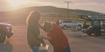 Movie still from “Hereditary” (2018), directed by Ari Aster – A woman is helping another woman with her purse; Medium shot, Over the shoulder angle