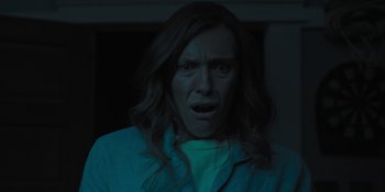 Movie still from “Hereditary” (2018), directed by Ari Aster – A woman with long hair is looking at the camera; Close Up shot, Low angle