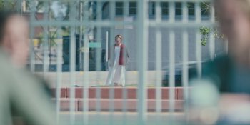 Movie still from “Hereditary” (2018), directed by Ari Aster – A woman in a white dress standing in front of a fence; Wide shot, Over the shoulder angle