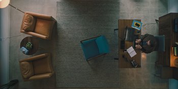 Movie still from “Hereditary” (2018), directed by Ari Aster – An overhead view of a chair and a desk; Extreme Wide shot, Overhead angle