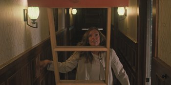 Movie still from “Hereditary” (2018), directed by Ari Aster – A woman standing in front of an open window; Medium shot, High angle