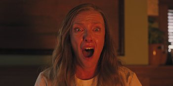 Movie still from “Hereditary” (2018), directed by Ari Aster – A person making a funny face; Close Up shot, Low angle