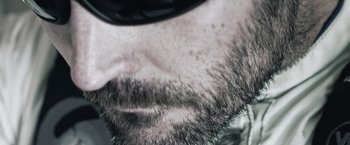 Movie still from “Hex” (2022), directed by Chris Johnston – View of a man's beard and sunglasses; Extreme Close Up shot, Over the shoulder angle