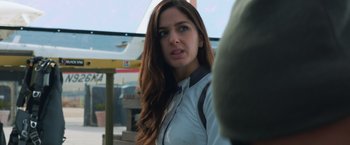 Movie still from “Hex” (2022), directed by Chris Johnston – A woman with long brown hair standing next to a bus; Close Up shot, Over the shoulder angle
