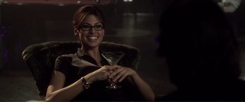 Movie still from “Hitch” (2005), directed by Andy Tennant – A woman sitting in a chair holding a martini glass; Medium shot, Over the shoulder angle