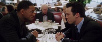 Movie still from “Hitch” (2005), directed by Andy Tennant – A group of people sitting at a table in a restaurant; Medium shot, Over the shoulder angle