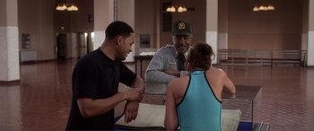 Movie still from “Hitch” (2005), directed by Andy Tennant – A man and a woman talking to a security guard; Medium shot, Over the shoulder angle