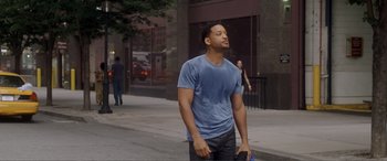 Movie still from “Hitch” (2005), directed by Andy Tennant – A man walking down a street holding a phone; Medium shot, Over the shoulder angle