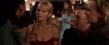 Movie still from “Hitch” (2005), directed by Andy Tennant – A woman in a red dress is holding a drink; Close Up shot, Over the shoulder angle