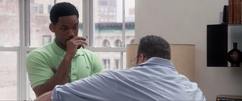 Movie still from “Hitch” (2005), directed by Andy Tennant – Two men are talking on their cell phones in front of a window; Medium shot, Over the shoulder angle