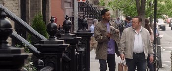 Movie still from “Hitch” (2005), directed by Andy Tennant – A man standing on a sidewalk reading a newspaper; Medium shot, Over the shoulder angle
