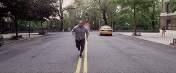 Movie still from “Hitch” (2005), directed by Andy Tennant – A man running down the middle of the street; Wide shot, High angle