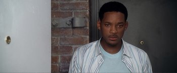 Movie still from “Hitch” (2005), directed by Andy Tennant – A man standing in front of a brick wall; Close Up shot, High angle