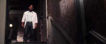 Movie still from “Hitch” (2005), directed by Andy Tennant – A man walking down the stairs of a building; Wide shot, Low angle