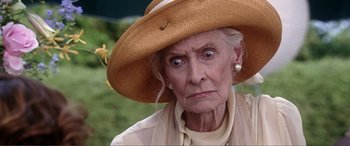 Movie still from “Hitch” (2005), directed by Andy Tennant – An old woman wearing a straw hat with a surprised look on her face; Close Up shot, Over the shoulder angle