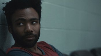 Movie still from “Atlanta” (2016), created by Donald Glover – A person sitting in a room; Close Up shot, Over the shoulder angle