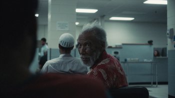 Movie still from “Atlanta” (2016), created by Donald Glover – An older man sitting next to another man in a room; Close Up shot, Over the shoulder angle