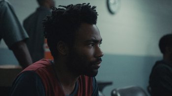 Movie still from “Atlanta” (2016), created by Donald Glover – A person sitting in a room; Close Up shot, Over the shoulder angle