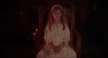 Movie still from “Hocus Pocus” (1993), directed by Kenny Ortega – A young girl in a white dress sitting in a chair; Medium shot, High angle