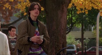 Movie still from “Hocus Pocus” (1993), directed by Kenny Ortega – A man standing next to a tree holding a paper; Medium shot, Low angle