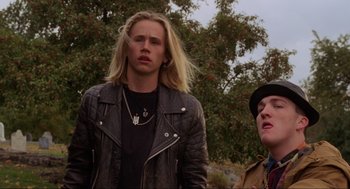 Movie still from “Hocus Pocus” (1993), directed by Kenny Ortega – A man with long blonde hair standing next to another man; Medium shot, Low angle