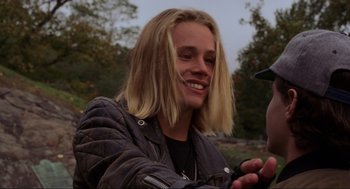 Movie still from “Hocus Pocus” (1993), directed by Kenny Ortega – A man with long blonde hair looking at a cell phone; Close Up shot, Over the shoulder angle