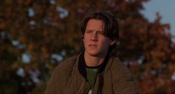 Movie still from “Hocus Pocus” (1993), directed by Kenny Ortega – A young man in a brown jacket looking to his left; Close Up shot, Low angle