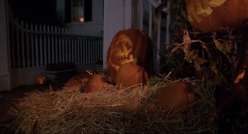 Movie still from “Hocus Pocus” (1993), directed by Kenny Ortega – A group of pumpkins sitting on top of a pile of hay; Wide shot, High angle