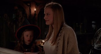 Movie still from “Hocus Pocus” (1993), directed by Kenny Ortega – A woman and a child are standing in a dark room; Close Up shot, Over the shoulder angle