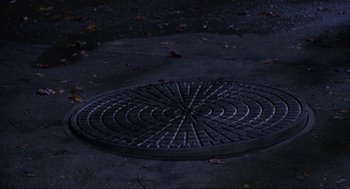 Movie still from “Hocus Pocus” (1993), directed by Kenny Ortega – A manhole cover in the middle of the night; Wide shot, Overhead angle
