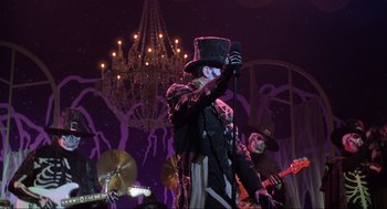 Movie still from “Hocus Pocus” (1993), directed by Kenny Ortega – A man wearing a top hat holding a microphone; Medium shot, Low angle