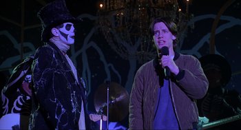 Movie still from “Hocus Pocus” (1993), directed by Kenny Ortega – Two men in costumes are on stage with a microphone; Medium shot, Over the shoulder angle