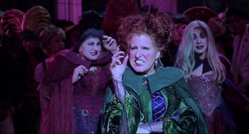 Movie still from “Hocus Pocus” (1993), directed by Kenny Ortega – A woman dressed as hocus pocus with another woman dressed as hocus pocus; Medium shot, Low angle