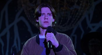 Movie still from “Hocus Pocus” (1993), directed by Kenny Ortega – A man holding a microphone while standing in a dark room; Close Up shot, Low angle