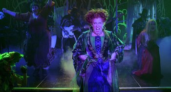 Movie still from “Hocus Pocus” (1993), directed by Kenny Ortega – A woman dressed as hocus pocus holding a knife; Medium shot, Low angle