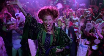 Movie still from “Hocus Pocus” (1993), directed by Kenny Ortega – A woman dressed as hocus pocus with a crowd behind her; Medium shot, High angle