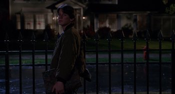 Movie still from “Hocus Pocus” (1993), directed by Kenny Ortega – A young man is standing in front of a metal fence; Medium shot, Over the shoulder angle