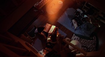 Movie still from “Hocus Pocus” (1993), directed by Kenny Ortega – A person sitting in a room reading a book; Extreme Wide shot, Overhead angle