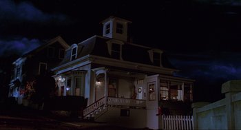 Movie still from “Hocus Pocus” (1993), directed by Kenny Ortega – A house that is lit up at night time; Wide shot, Low angle