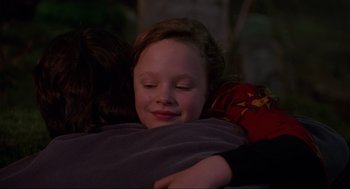 Movie still from “Hocus Pocus” (1993), directed by Kenny Ortega – A little girl laying on top of a blanket hugging another girl; Close Up shot, Over the shoulder angle